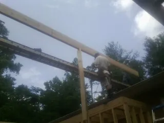 Carpenter setting a ridge beam over a new addition frame — Ice Dam Removal by Roofing Brothers in Rockvale
