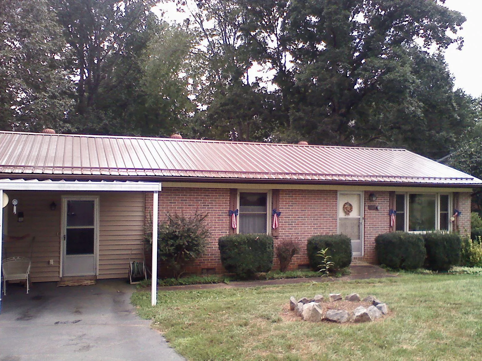 Bronze metal roof and carport on a brick ranch home — Roof Repair work by our crew in Rockvale